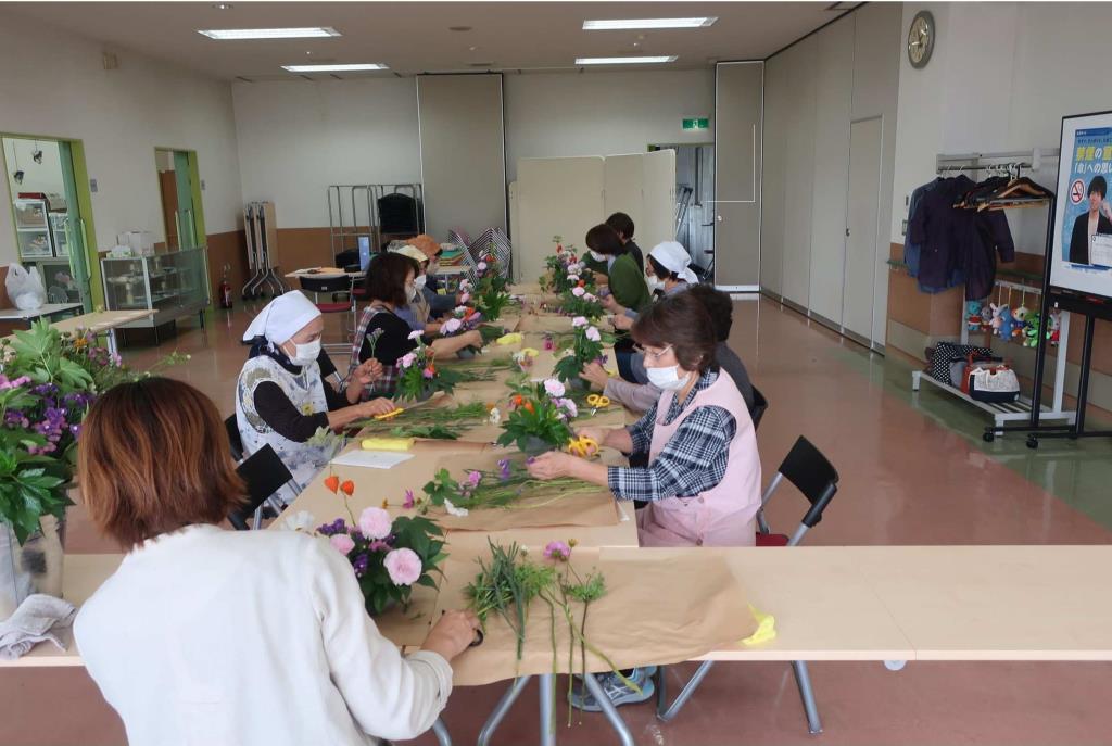 高齢者に向けたフラワーアレンジメントの様子の画像